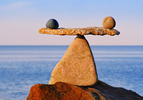 stones on beach balanced on large rock
